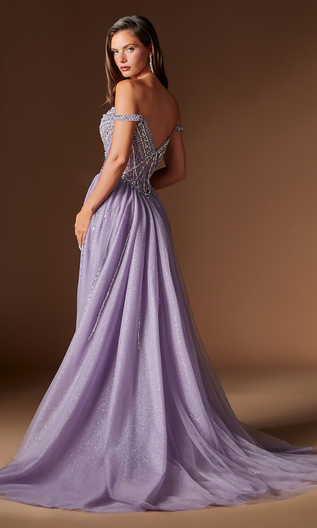 A woman poses against a plain brown background in the Ladivine CDS570, a long lavender prom dress with off-the-shoulder beaded detailing—ideal for formal events.